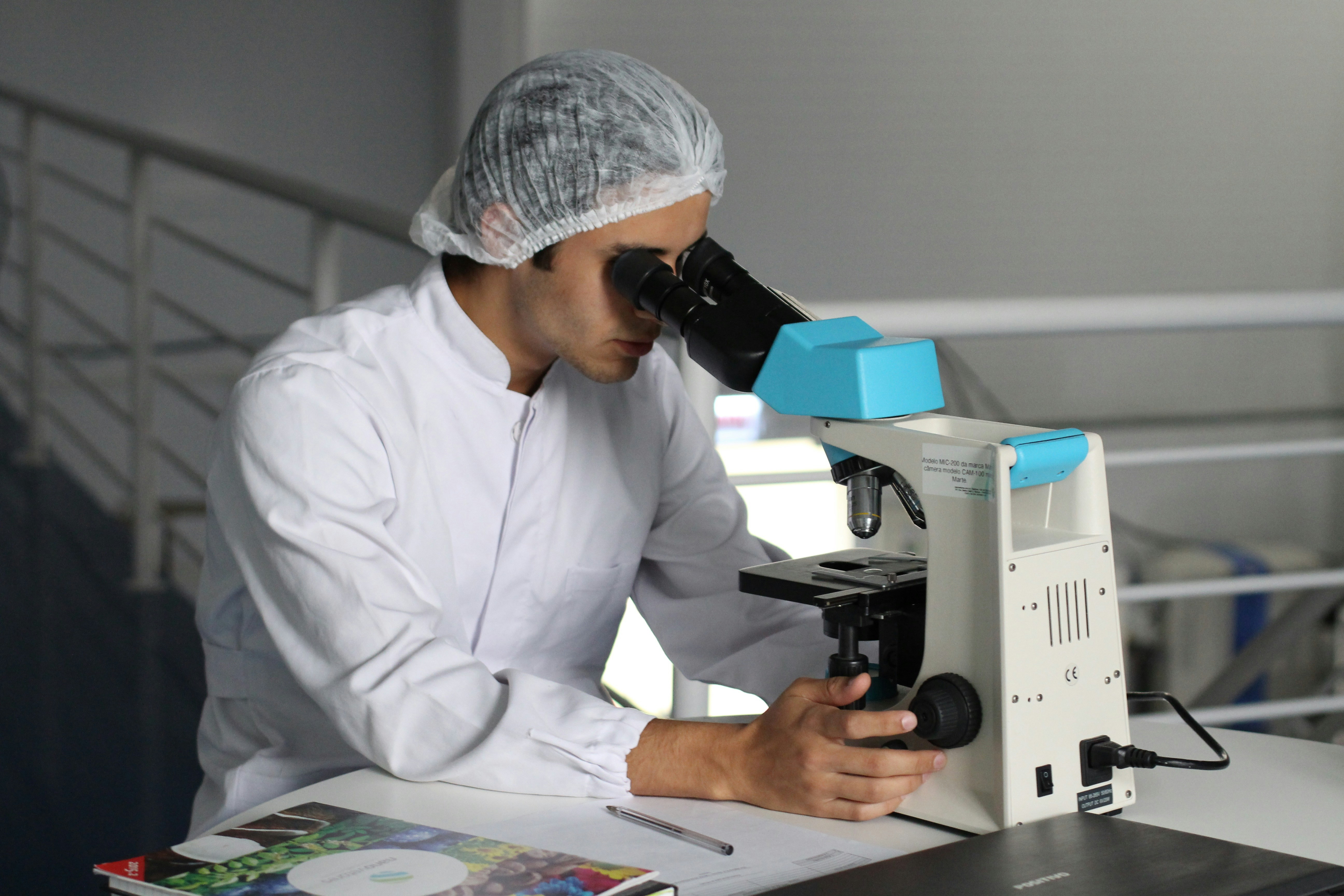 Researcher examining skin samples under microscope for GHK-Cu copper peptide study